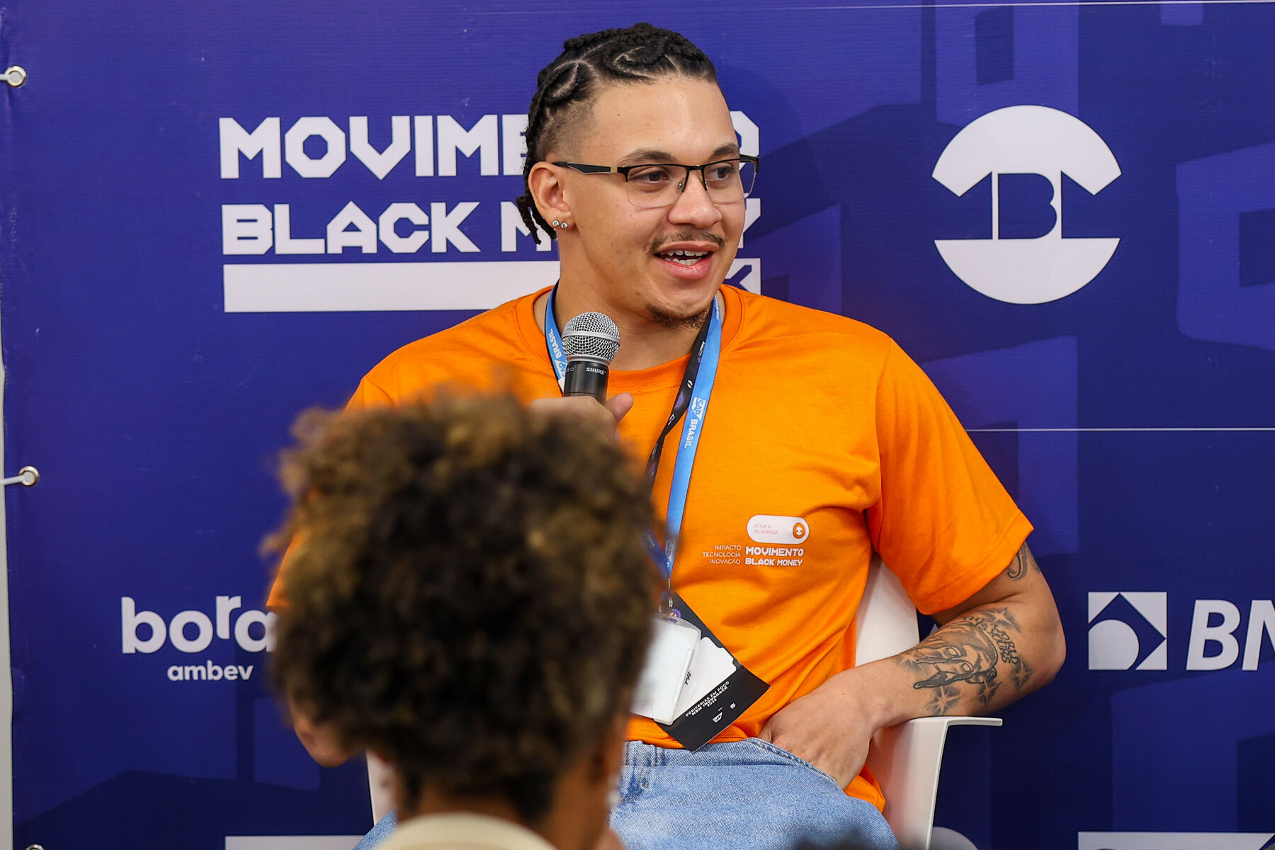 Participante falando ao microfone em uma conversa de mentoria do Movimento Black Money